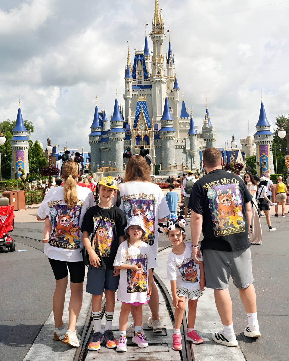 A family in Mouse House tees in front of the castle